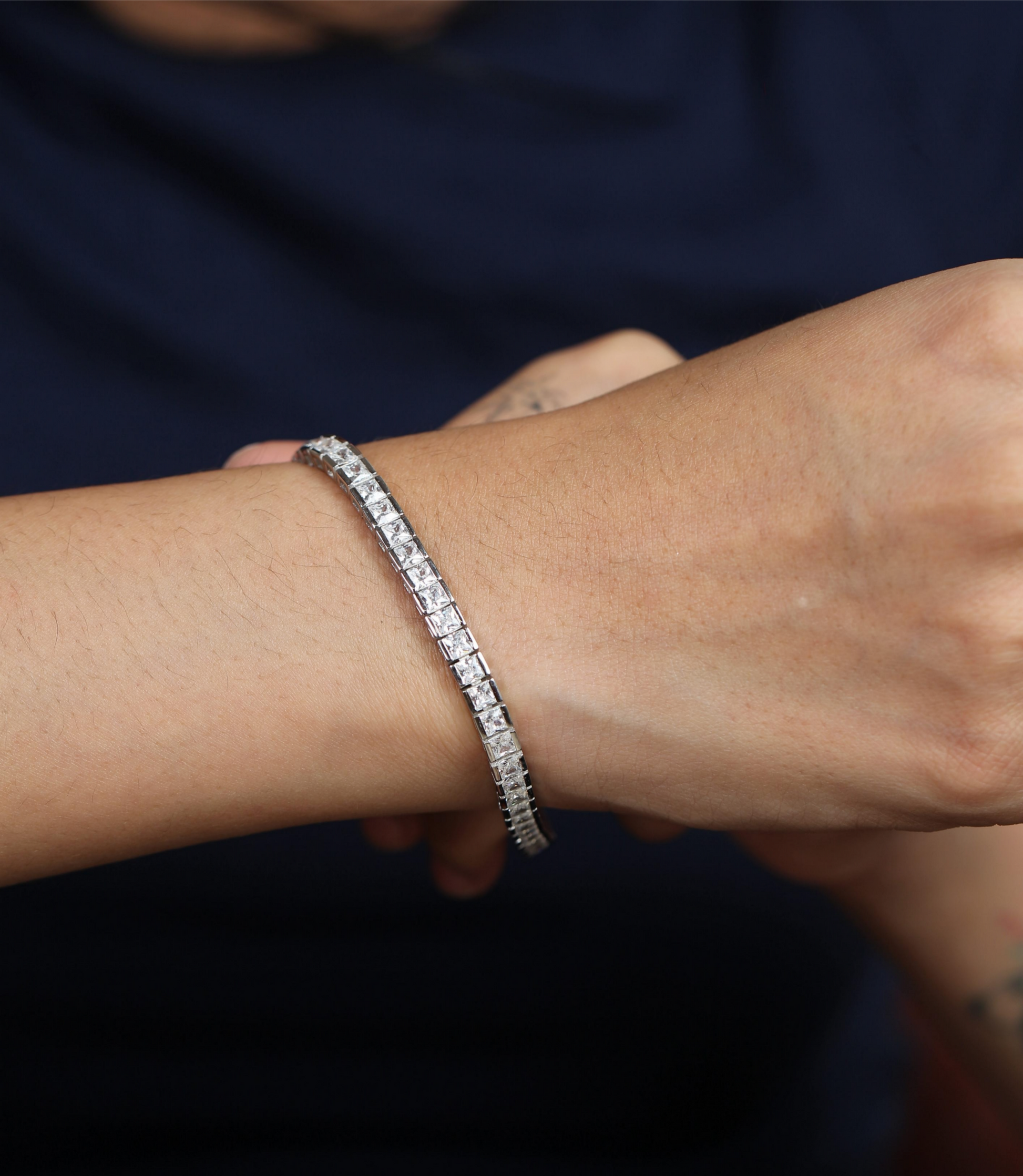 925 silver tennis bracelet worn on wrist with neatly set square-cut stones