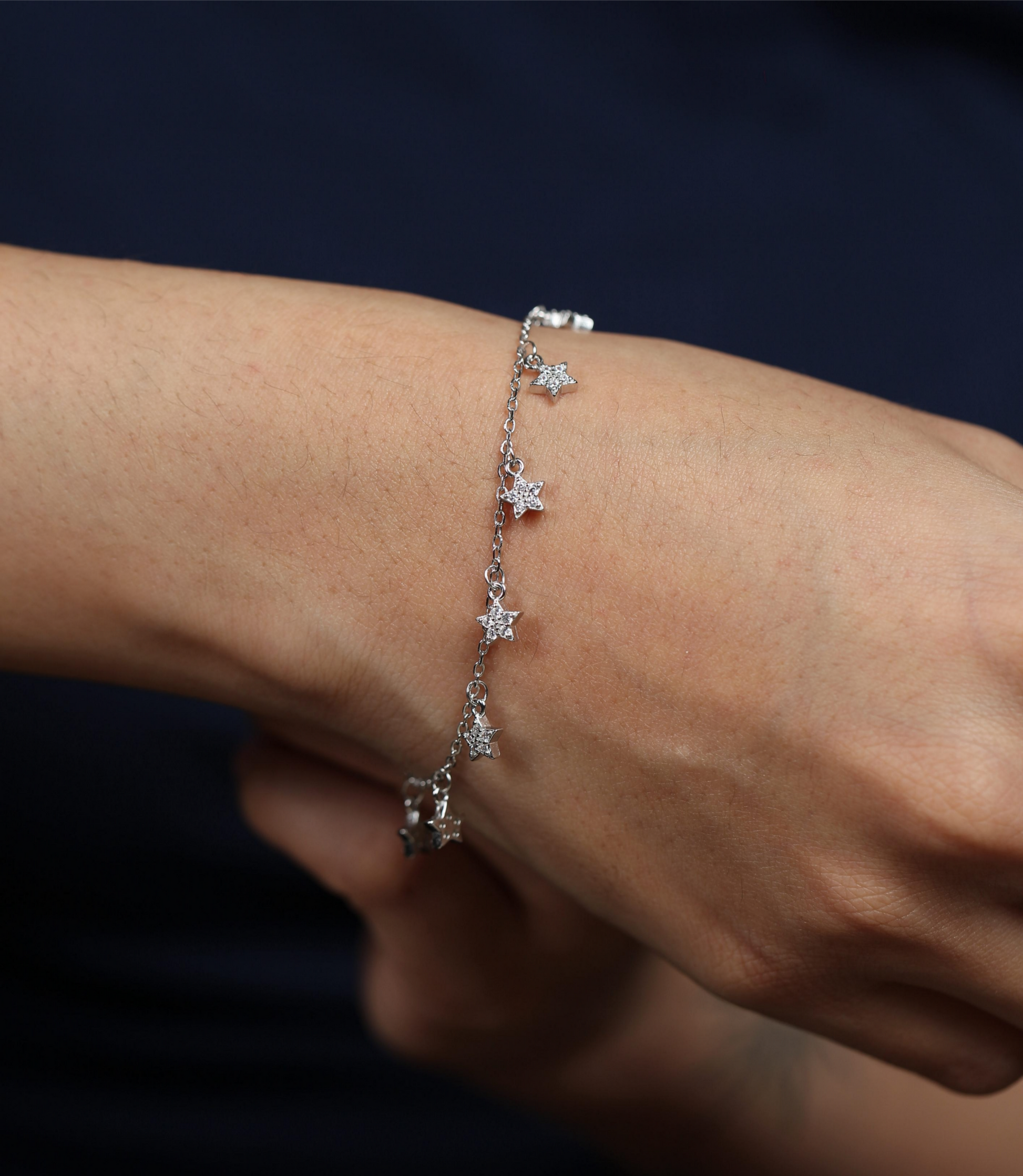 925 silver star charm bracelet worn on wrist with hanging star-shaped pendants