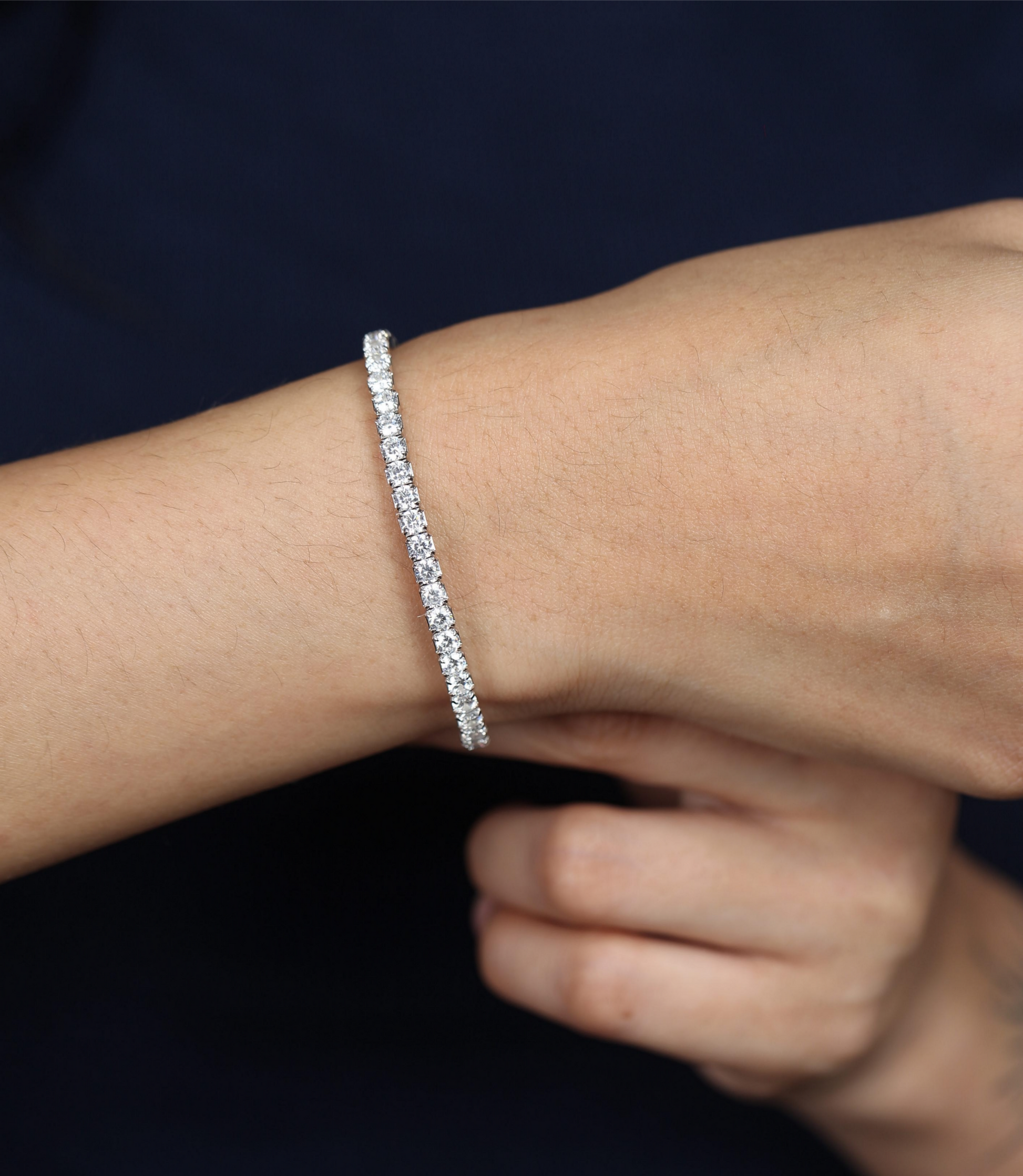 925 silver tennis bracelet with stone setting worn by woman